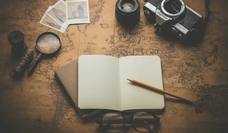 flat ray photography of book, pencil, camera, and with lens